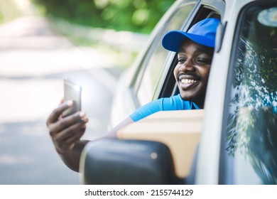 African delivery man or courier with box calling phone to customer. Delivery and technology concept