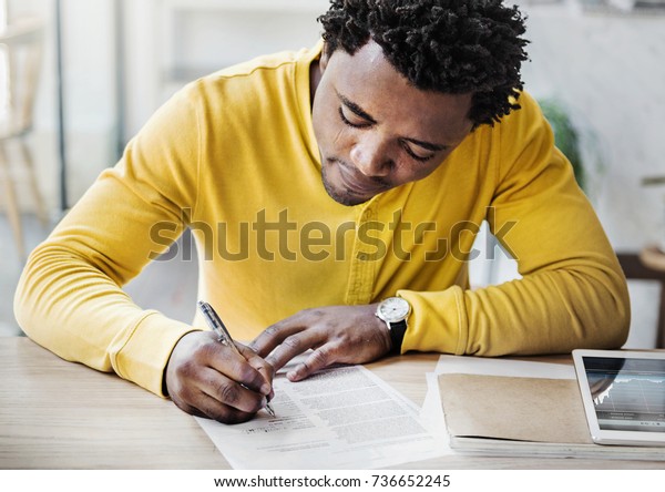 African descent man\
is filling an\
application