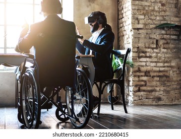 African Disabled Businessman Working With New Wearable Technology With His Colleague During Business Meeting At Office