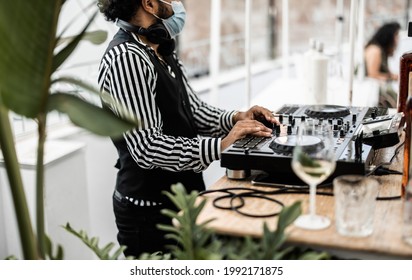 African Dj Playing Music At Cocktail Bar Outdoor While Wearing Face Safety Mask - Focus On Right Hand