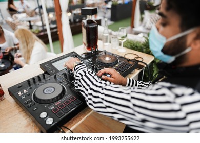 African Dj Playing Music At Cocktail Bar Outdoor While Wearing Face Safety Mask - Focus On Right Hand