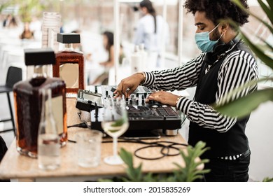 African Dj Playing Music At Cocktail Bar Outdoor While Wearing Face Safety Mask - Main Focus On Top Hand