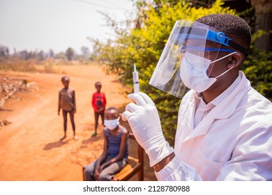 An African Doctor Is About To Vaccinate Children To Prevent Coronavirus Infection. Vaccination Concept In Africa