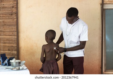 African Doctor Examining Little Young African Black Boy At Hospital Facility Near Bamako, Mali.