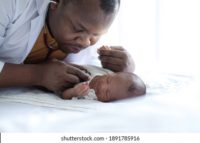 African Doctor Listening To Heart Beat  Of Newborn Baby With Stethoscope, Newborn Baby 15 Days Old Lying On Bed