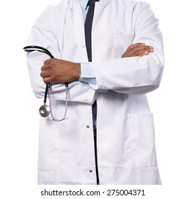 African doctor, surgeon, cardiologist or nurse in a white lab coat, standing with folded arms holding a stethoscope in her hands, torso view isolated on white