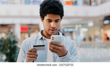 African Dominican Guy Doing Online Shopping Transaction In Net Man With Phone Enters Card Number Problems With Finance Error In Mobile App Authorization Denied Lack Of Money In Bank Purchase Trouble