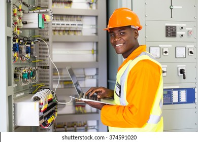 african electrical worker using laptop computer checking transformer