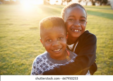 African elementary school boy and girl hugging outdoors
