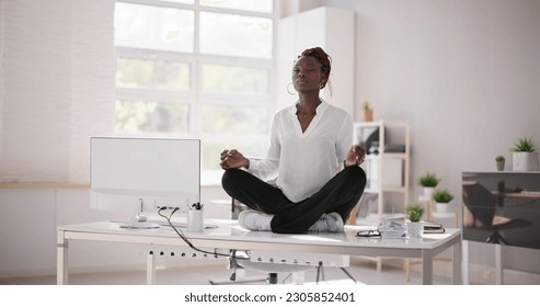 African Employee Doing Mental Health Yoga Meditation In Office - Powered by Shutterstock