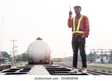 African engineer man control a the train on railway with talking by radio communication or walkie talkie