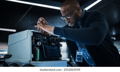 African Engineer Using a Screwdriver While Developing a Remotely Controlled Delivery Robot. Black Specialist Working in High Tech Research Laboratory with Modern Equipment