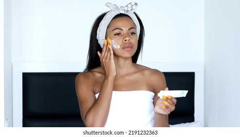 African Ethnicity Beautiful Woman Apply Facial Day Or Night Cream Smile Looking At Camera. Professional Cosmetics Skin Care Remedy, Beauty Treatment Advertisement Concept.