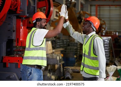 African factory workers or engineer giving high five in the factory