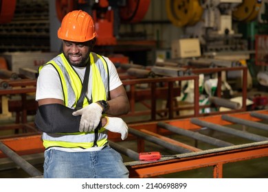African factory workers or engineer wearing bandages splint, pain in elbow and ache in arm from hard work in the factory