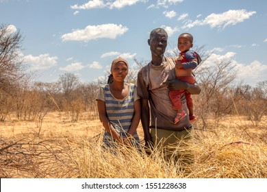 African Family With A Child In A Village In  Botswana Standing In Front Of  The Bush In Kalahari , Botswana