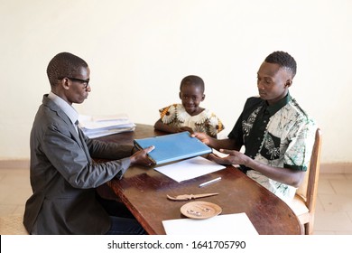 African Family Of Dad And Child Getting Adoption Documents Or Getting School Registration Documents In African Office