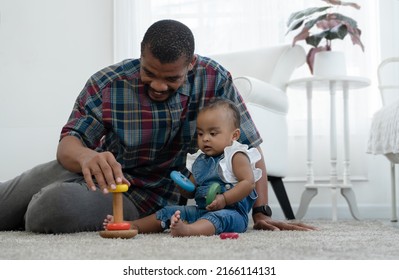 African Family, Happy Father And Little Cute Daughter Toddler Baby Playing Blocks Toy And Sitting On Floor Together At Bedroom At Home. Development, Education, Growth And Child Care Concept