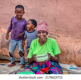 African Family In The Village, Sitting In Their Yard, Eating