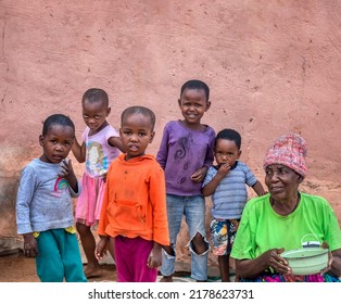 African Family In The Village, Sitting In Their Yard, Eating