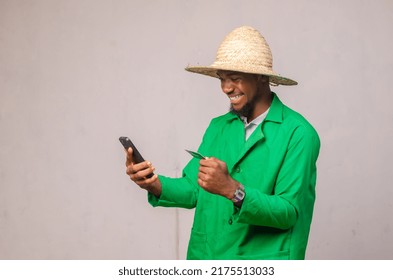 African Farmer Using His Phone And Bank Card