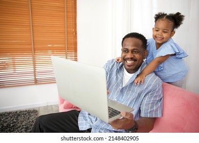 African father with daughter using laptop computer and online video call to someone in the home - Powered by Shutterstock