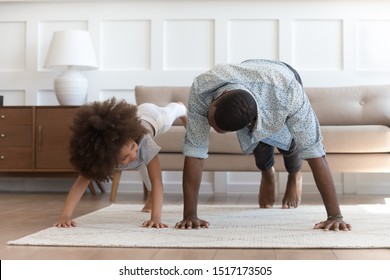 African father and small daughter in casual clothes do pushup pressup exercise on carpet on warm floor in living room, sporty lifestyle, getting physically stronger, have fun, pastime with kid concept - Shutterstock ID 1517173505