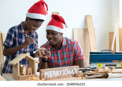 African father and son paint on wooden toy for Christmas at wood workshop, Christmas concept - Powered by Shutterstock