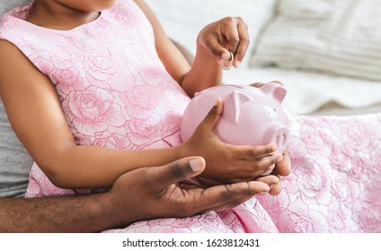 African Father Teaching Little Daughter Saving Money In Piggy Bank, Financial Literacy, Cropped