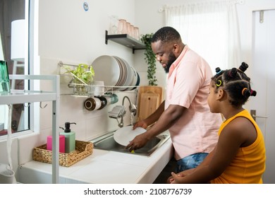 African father teaching little daughter washing dishes in the sink on kitchen counter with talking together after having dinner. Happy family dad and child girl kid spending time together at home. - Powered by Shutterstock