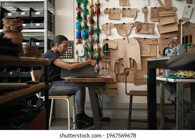 African female artisan using a sewing machine in her workshop - Powered by Shutterstock