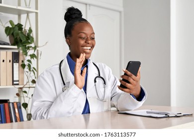 African female doctor holding phone talk to patient make telemedicine online video call. Afro american therapist remote consultation in telemedicine virtual mobile chat application. Telehealth concept