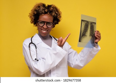 African Female Doctor Looking At A Lungs Or Torso Xray. Medical Student Examines X-rays Of The Lungs