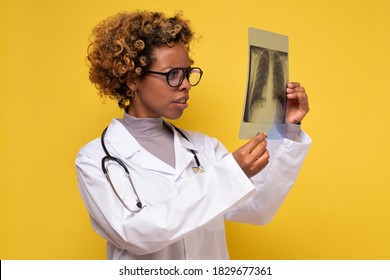 African Female Doctor Looking At A Lungs Or Torso Xray. Medical Student Examines X-rays Of The Lungs