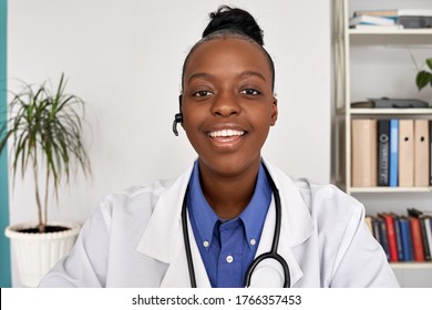 African female doctor wear headset make online telemedicine video call consult patient. Afro american black woman therapist talking to camera in remote videoconference chat. Webcam view, face headshot