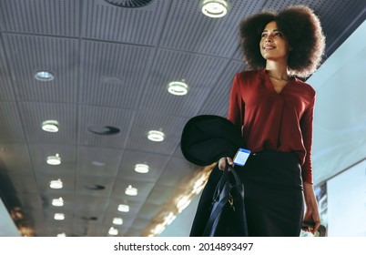 African female traveler moving to the terminal gate for check in boarding at the airport. Woman passenger going on business trip. - Powered by Shutterstock