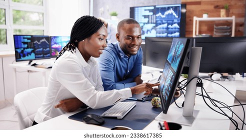 African Financial Data Analysts Using Performance Dashboard On Screens In Office