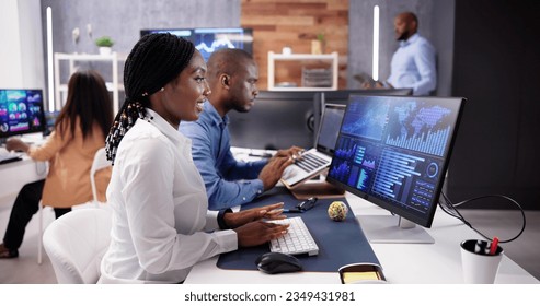 African Financial Data Analysts Using Performance Dashboard On Screens In Office