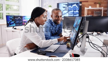 African Financial Data Analysts Using Performance Dashboard On Screens In Office