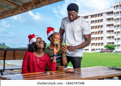 African Friends Sitting At A Table And Celebrating Christmas Outdoor