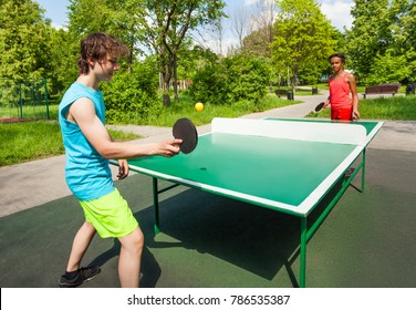 African Girl And Boy Playing Ping Pong Outside During Summer Sunny Day