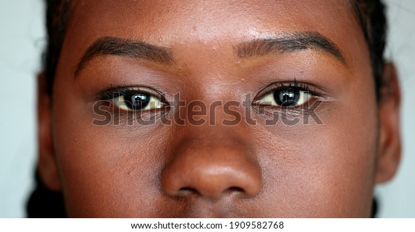 African girl eyes staring camera.\
Macro close-up Mixed race young woman eye, casual real\
person