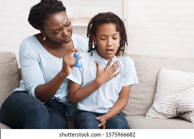 African Girl Having Asthma Attack, Worried Mom Giving Her Inhaler For Relief. Copy Space