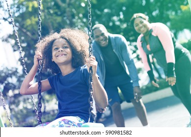 African Girl Having Fun With Swing And Family