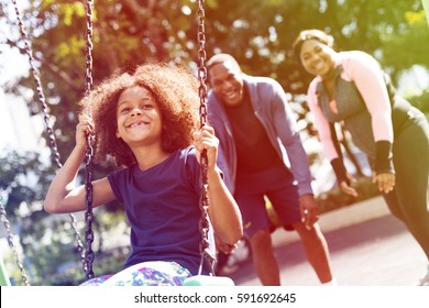 African Girl Having Fun With Swing And Family