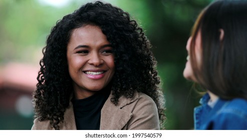 African Girl Listening To Friend In Conversation Outside, Diverse Female Friends Talk At Park