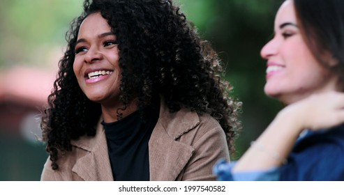 African Girl Listening To Friend In Conversation Outside, Diverse Female Friends Talk At Park