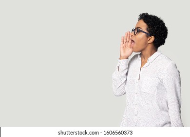 African girl pose aside on grey background looking at copy space holds hand near mouth call somebody speaks loud make announcement about grand sell-out, falling prices better commercial offer concept - Shutterstock ID 1606560373
