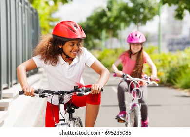 African girl racing on bicycle with her friend