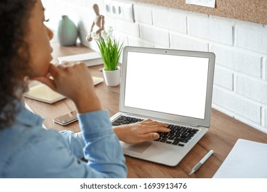 African girl student watching video course, distance e-learning, studying with online teacher by webcam. Remote education, work from home concept. Over shoulder close up laptop mock up screen view.
